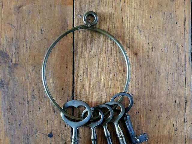 Antique key ring with ornate keys on wood, illustrative photo