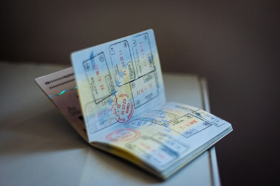 Open passport with entry and exit stamps, illustrative photo